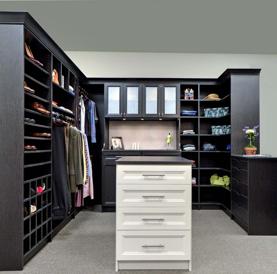dark brown walk in closet with counter at the center